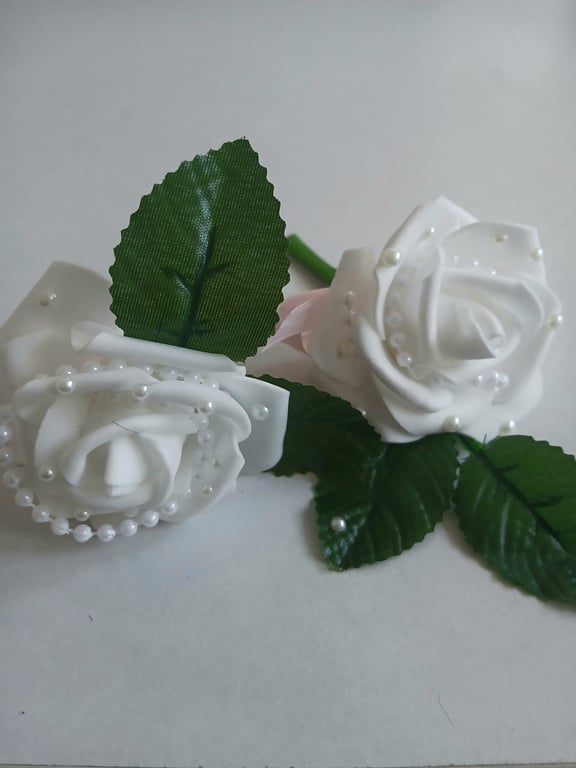 White buttonholes with pearl centre.