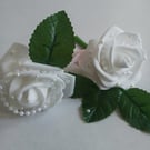White buttonholes with pearl centre.