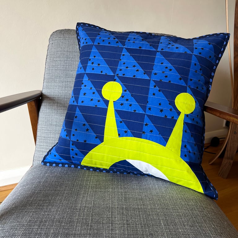 Square quilted cushion with a space alien