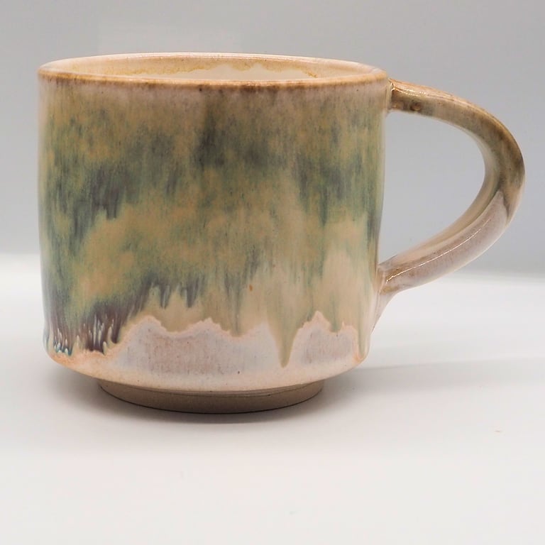 Large stoneware pottery mug finished in green, cream, white glaze.