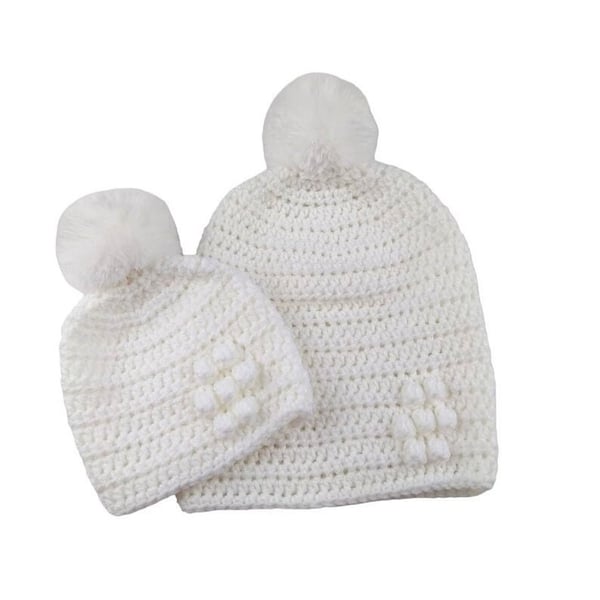 Matching ladies and baby white crocheted hats with detachable faux fur pompoms