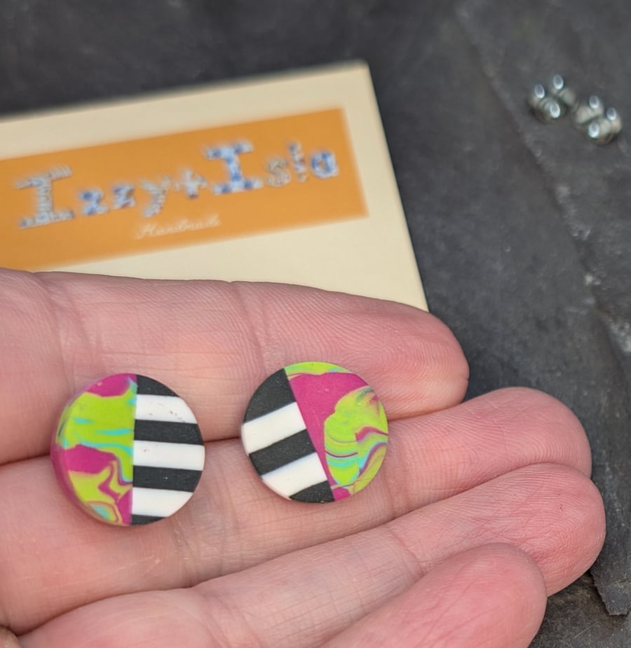 Stud earrings featuring monochrome strips and hot pink marble effect