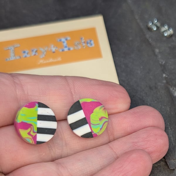 Stud earrings featuring monochrome strips and hot pink marble effect
