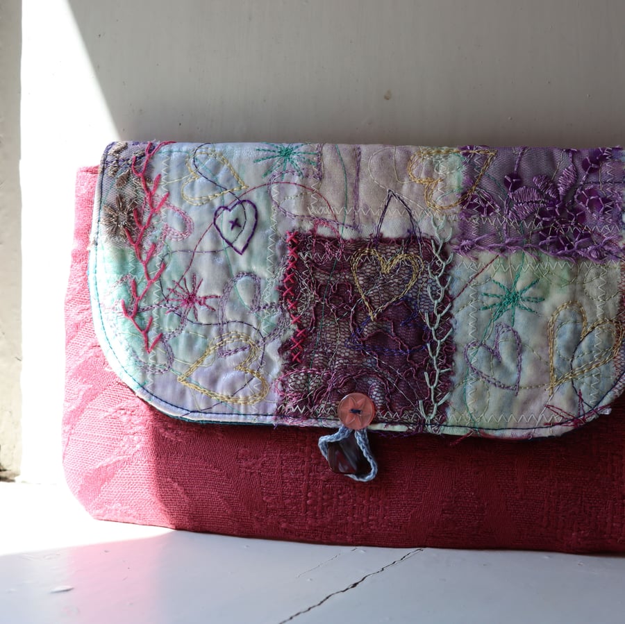 Raspberry pink clutch bag with textile art feature