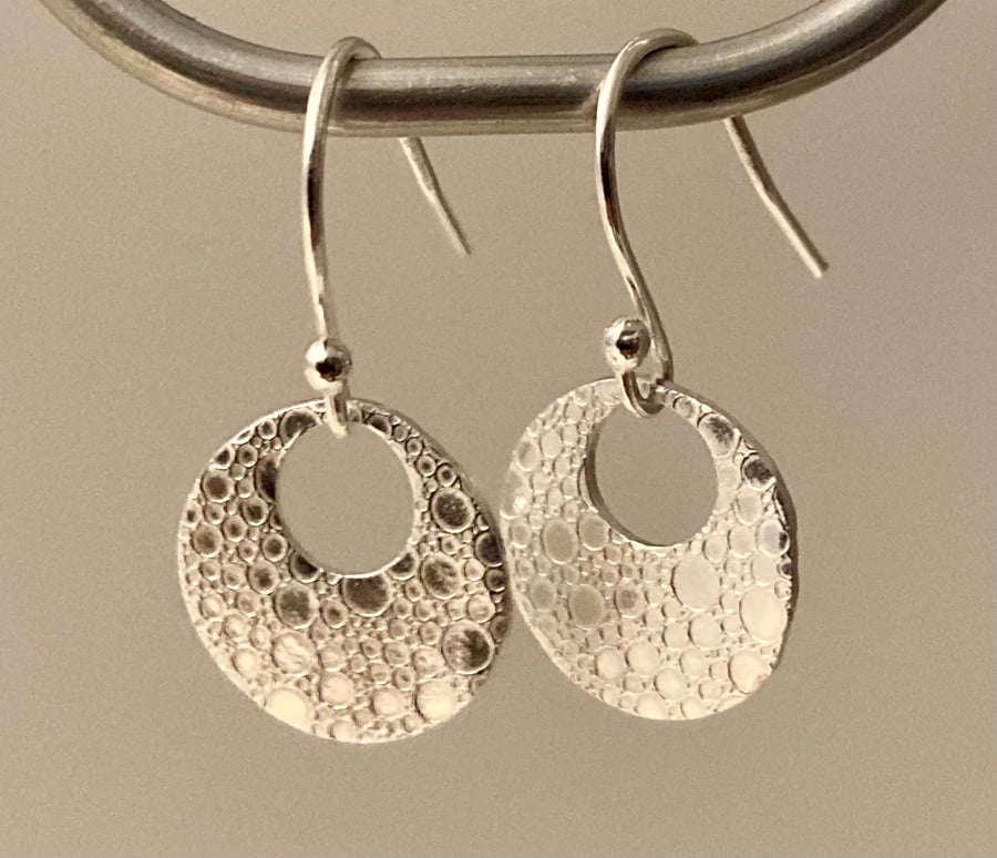 Circular earrings with bubble texture. 