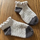 A pair of handmade cream and grey crochet socks with a frilly top in UK size 4