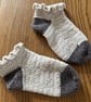 A pair of handmade cream and grey crochet socks with a frilly top in UK size 4