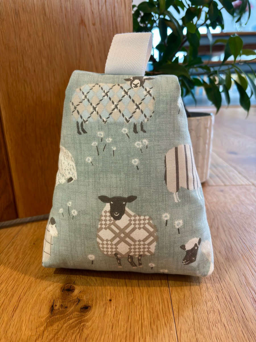 Cotton fabric doorstop in duck egg blue, fun sheep print, filled with pebbles