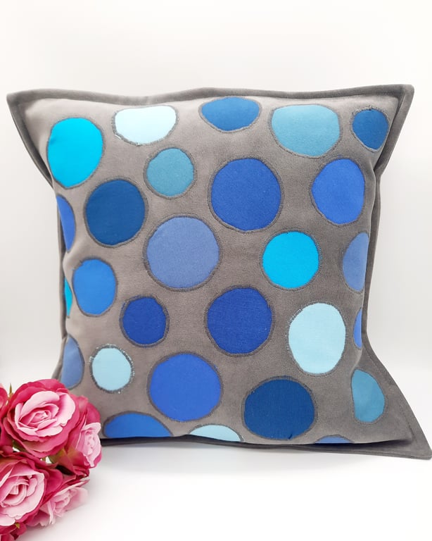 Grey cushion cover with blue circular applique.  