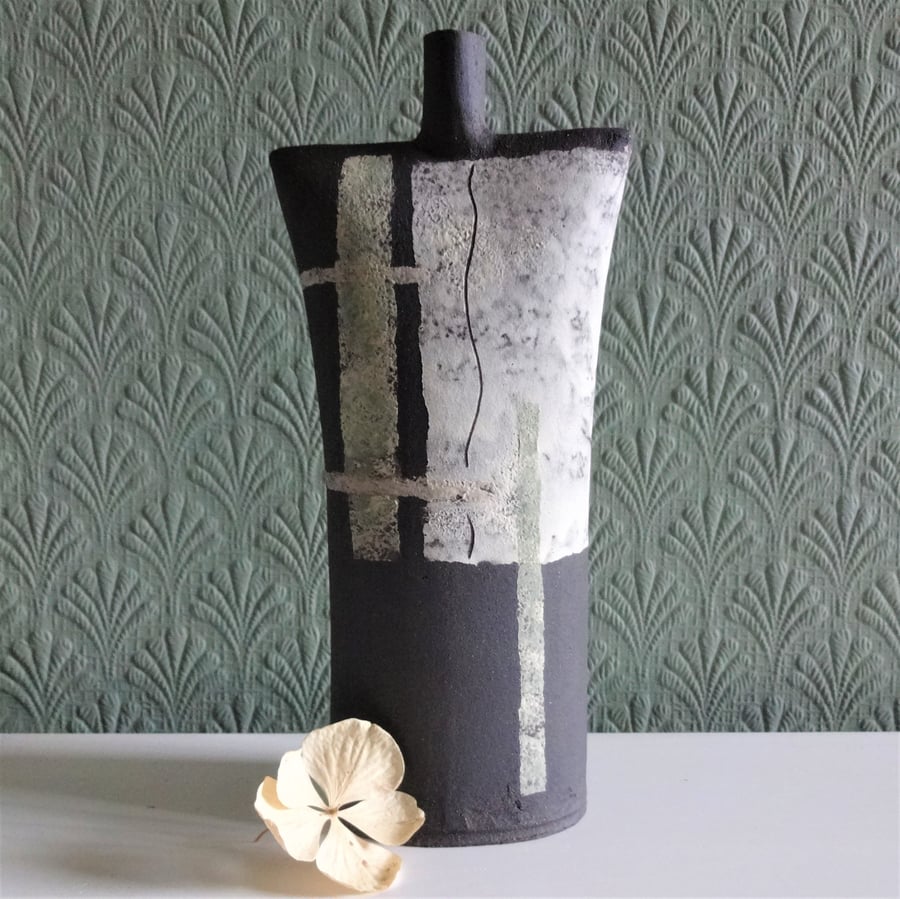 Abstract ceramic sculpture, black stoneware with decorative panels and motifs.