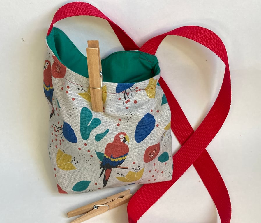 Peg bag with shoulder strap. Multi-coloured parrot fabric.