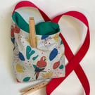 Peg bag with shoulder strap. Multi-coloured parrot fabric.