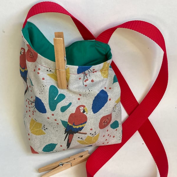 Peg bag with shoulder strap. Multi-coloured parrot fabric.