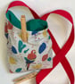 Peg bag with shoulder strap. Multi-coloured parrot fabric.