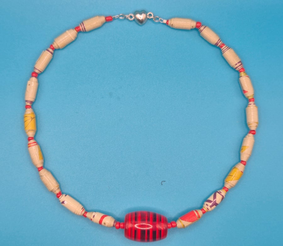 Necklace made with wall paper and vibrant orange bead 