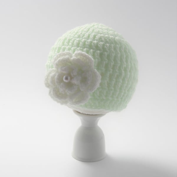 Newborn baby hat in green with a white crochet flower with a pearl attached