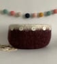 FELTED 'FUSSPOT' BOWL, desk tidy . Maroon, white rim  ( with button detail ) .