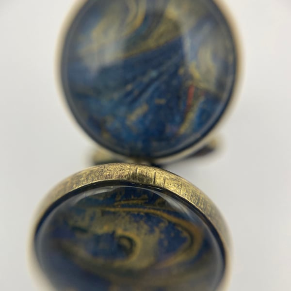 Pair of cuff links with blue and gold pigments 