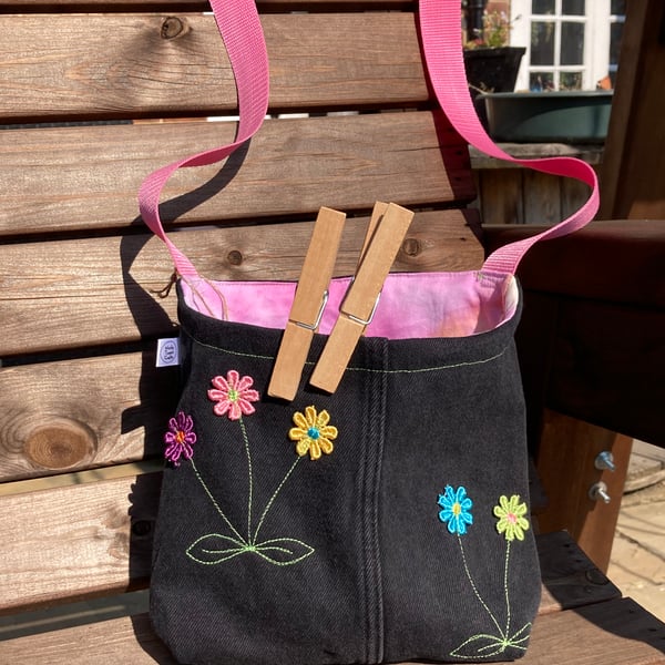 Peg bag with pink shoulder strap. Recycled denim with daisies.
