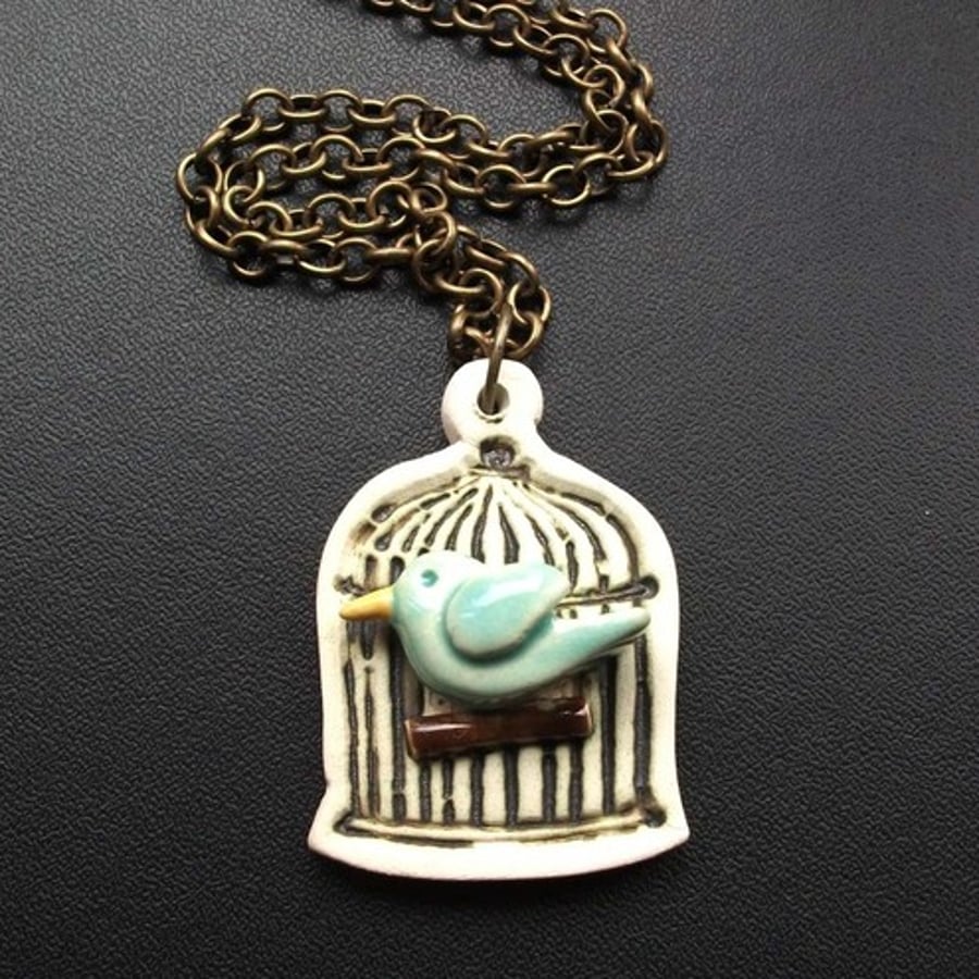 Bird in a cage ceramic pendant