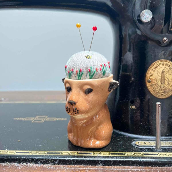 Pin cushion in a vintage dog or lion cub egg cup embroidered flowers and bee