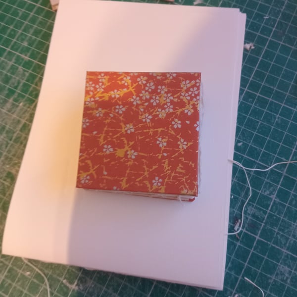 Mini sketchbook approx 8 cm square with cotton rag paper inside open spine 