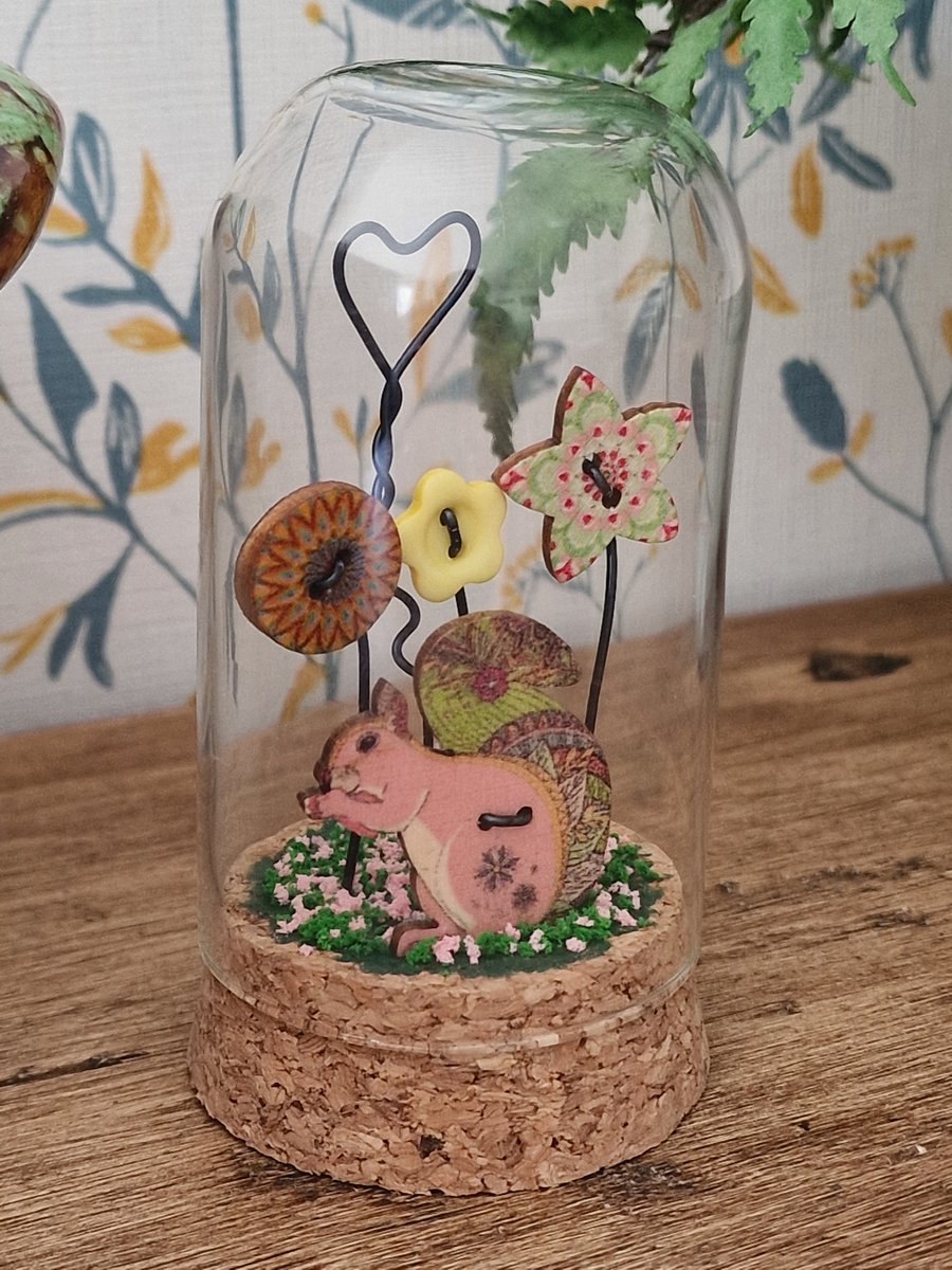 A cute Squirrel in a glass dome scene. Miniature woodland scene.