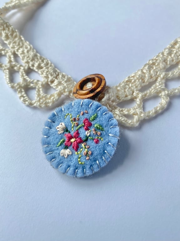 Crochet lace collar with blue embroidered wool felt pendant