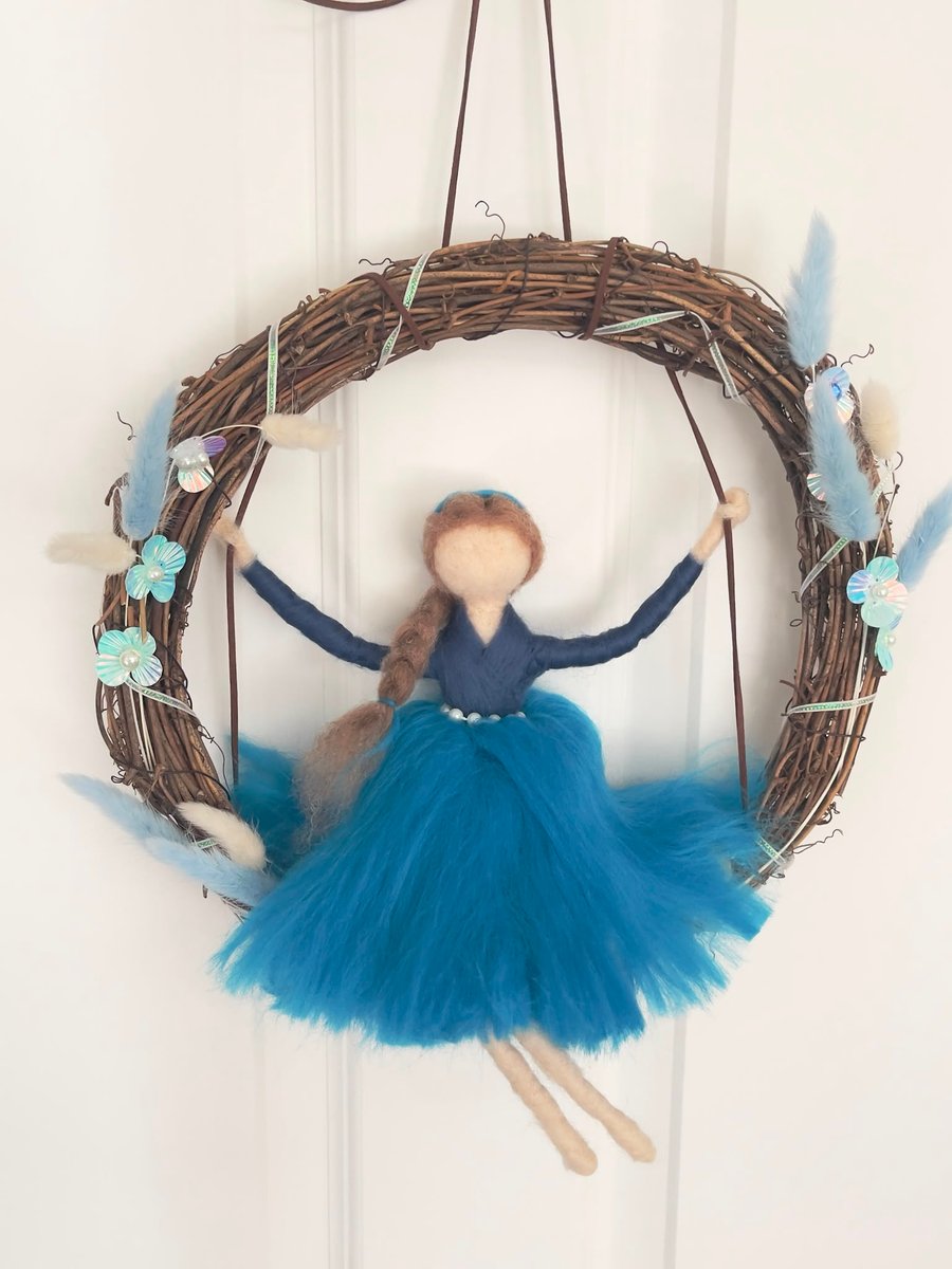 Blue fairy on swing in wreath