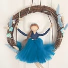 Blue fairy on swing in wreath