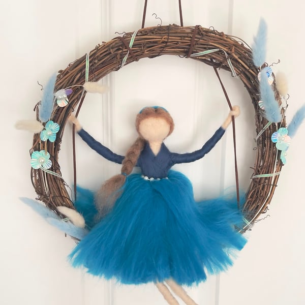 Blue fairy on swing in wreath