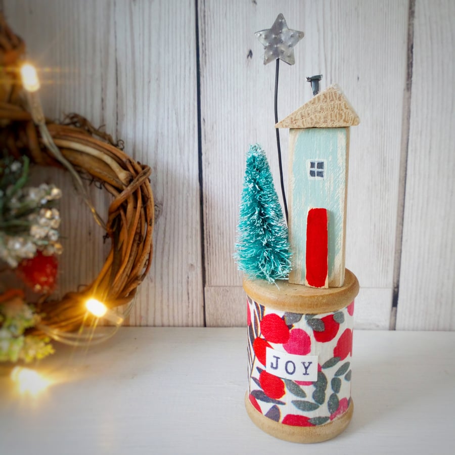 Christmas house and tree with star on a vintage bobbin
