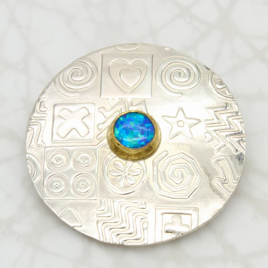 Contemporary round sterling silver brooch featuring a blue Opal, gemstone choice