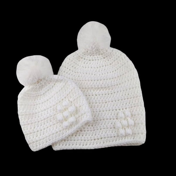 Matching ladies and baby white crocheted hats with detachable faux fur pompoms