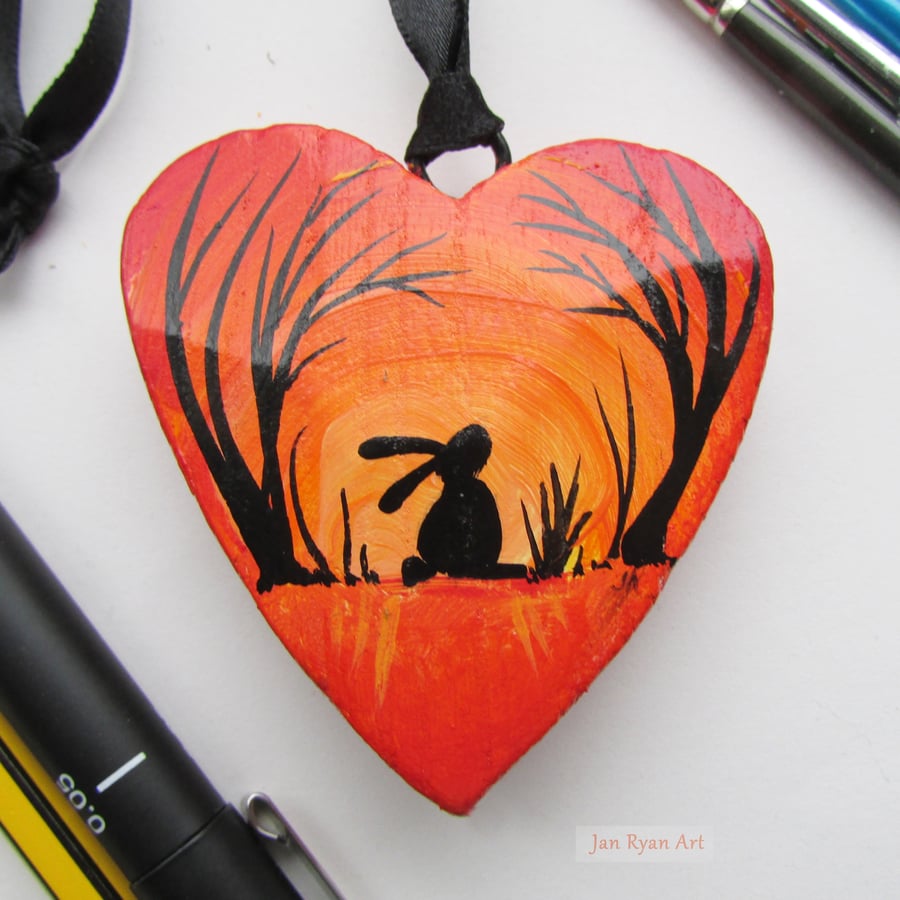 Hare or Rabbit silhouette by sunrise, yellow orange hanging heart