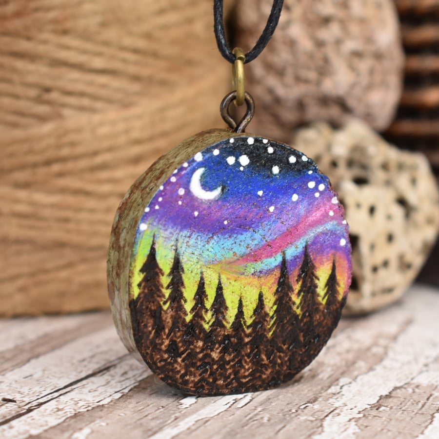 Forest skies pyrography pendant. Rustic branch slice with Northern Lights.