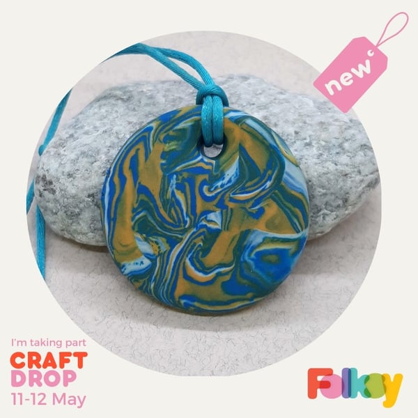 Round pendant in a turquoise, yellow and white polymer clay mix