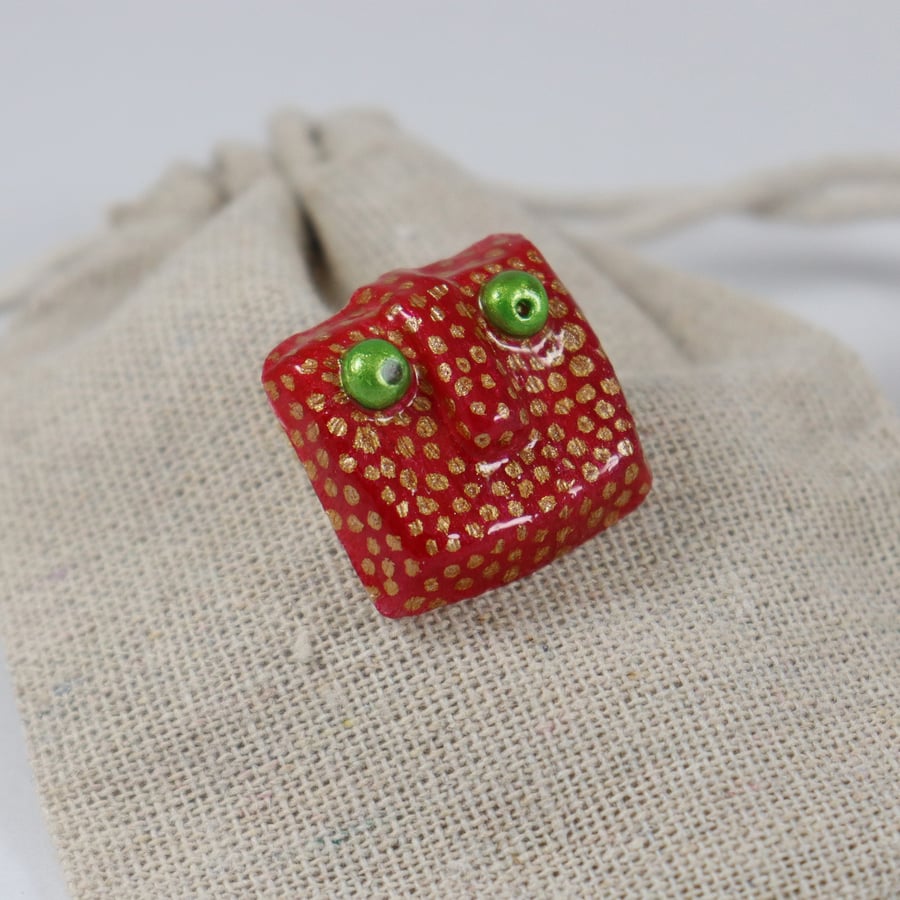 red and gold monster face brooch