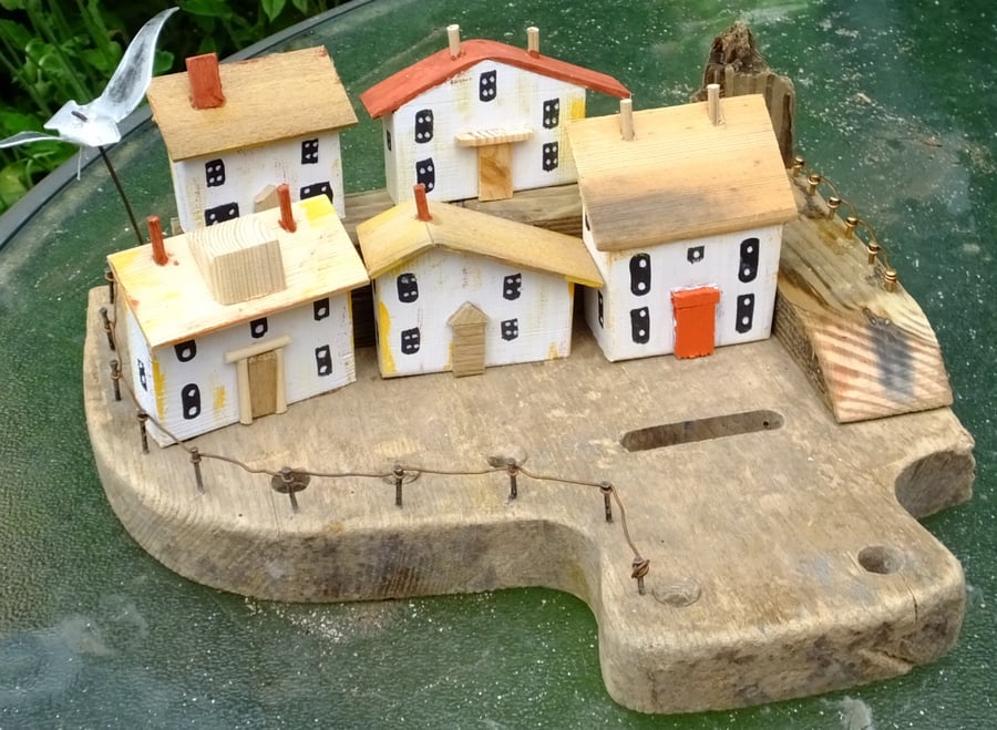 Handpainted country cottages on driftwood base supposed to be harbour side scene