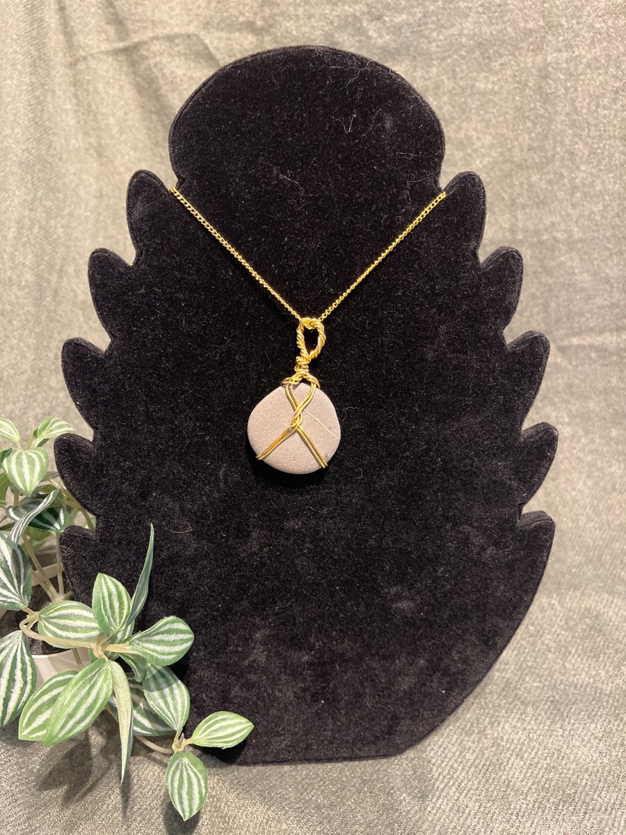 Beautiful wire wrapped grey pebble pendant on gold coloured chain. 