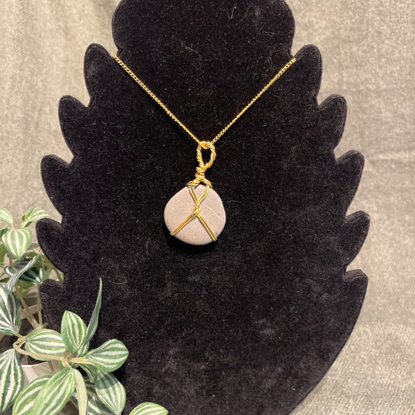 Beautiful wire wrapped grey pebble pendant on gold coloured chain. 