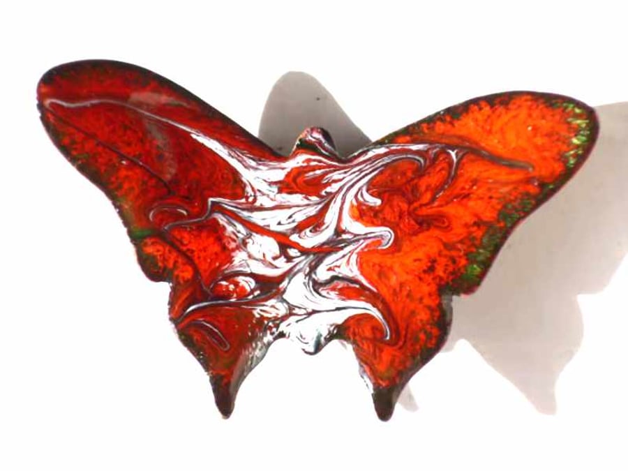 butterfly brooch, scrolled white and grey on red over clear enamel