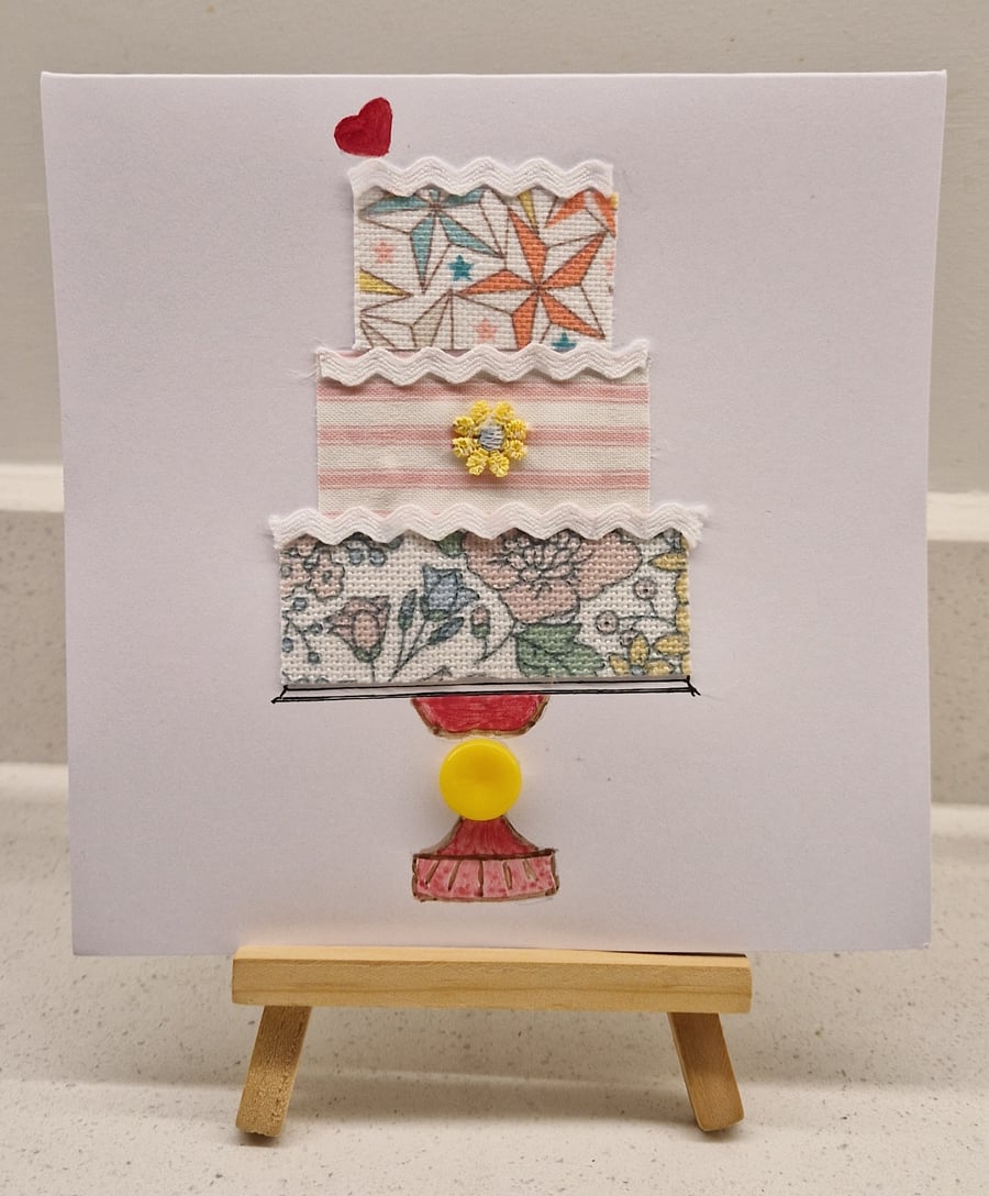 Pretty birtihday card of a birthday cake on a stand with a love heart 