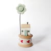 Tiny oak house with clay flower on vintage wooden bobbin