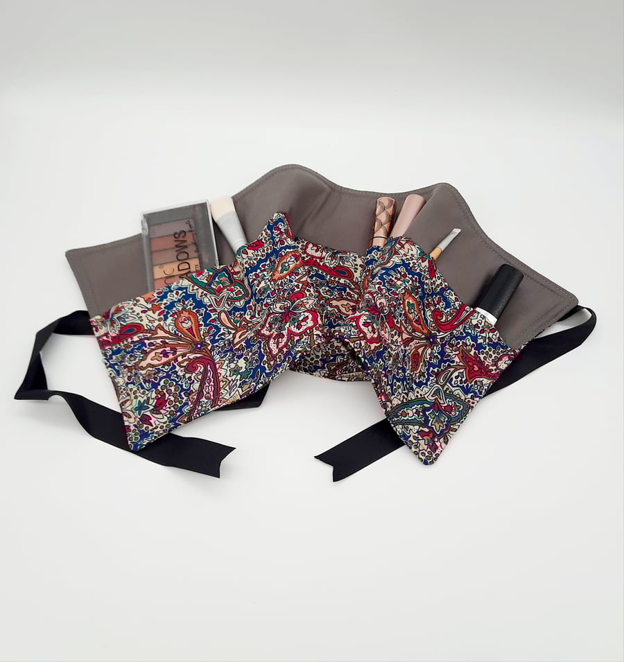 Teal patterned makeup wrap with 14 pockets. 