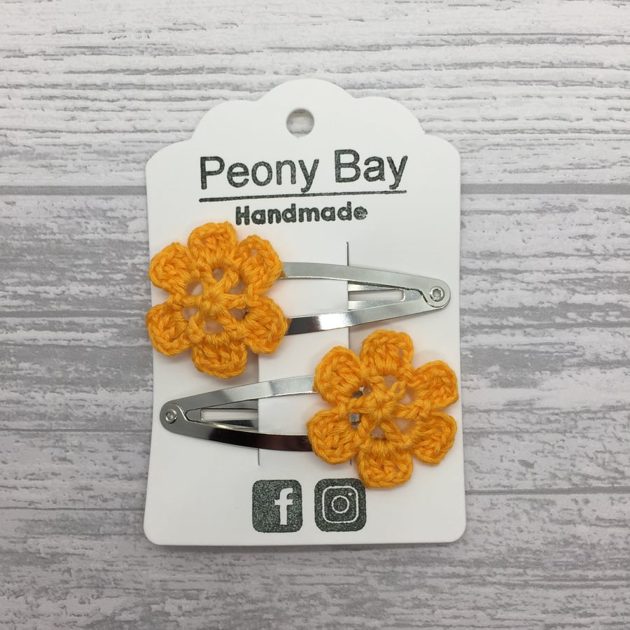 Girl’s hair clips with orange crocheted flowers