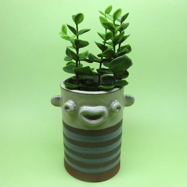 Ceramic face pot with sticking out ears and stripy grey top