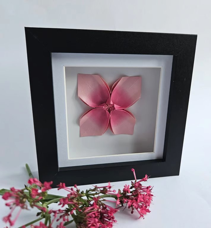 Pink origami flower in a shadow box frame