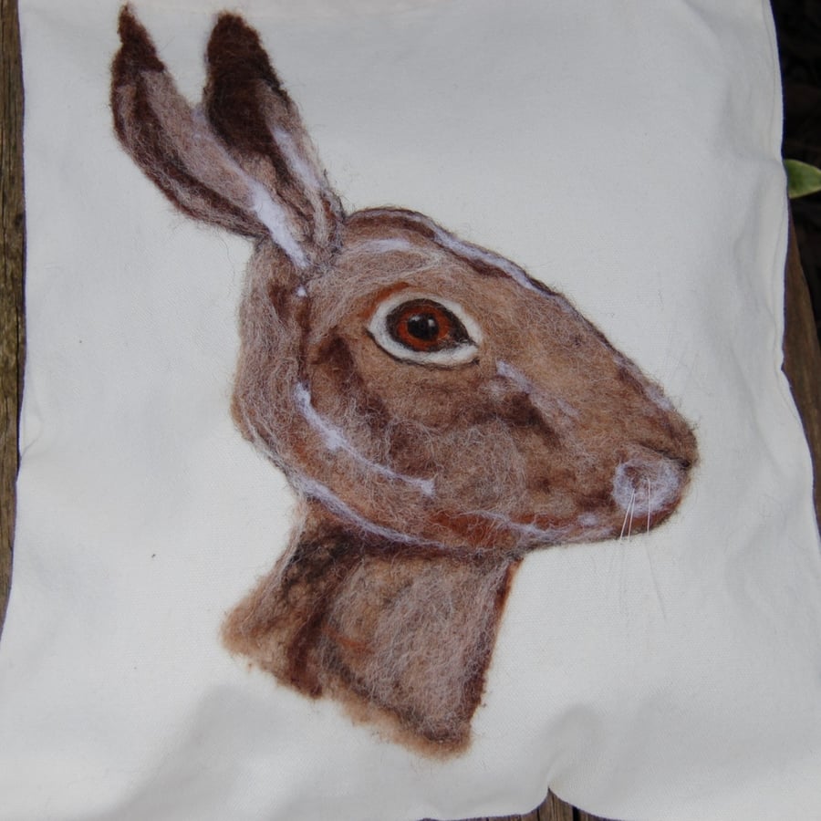 A needle felted hare portrait on a Canvas tote bag.