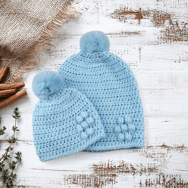 Matching ladies and baby blue crocheted hats with detachable faux fur pompoms 